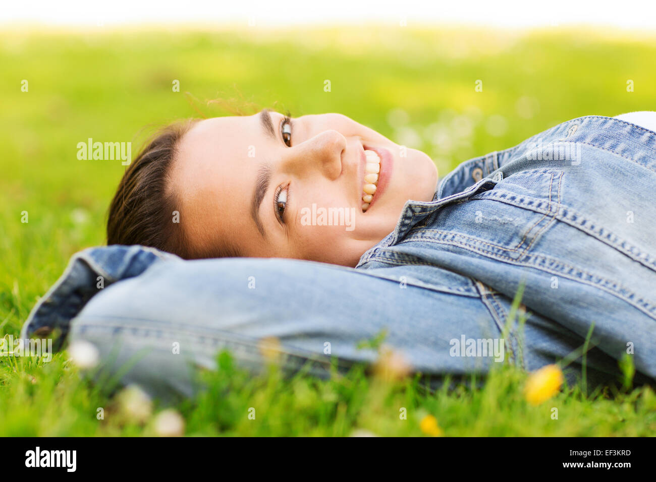 smiling young girl lying on grass Stock Photo - Alamy