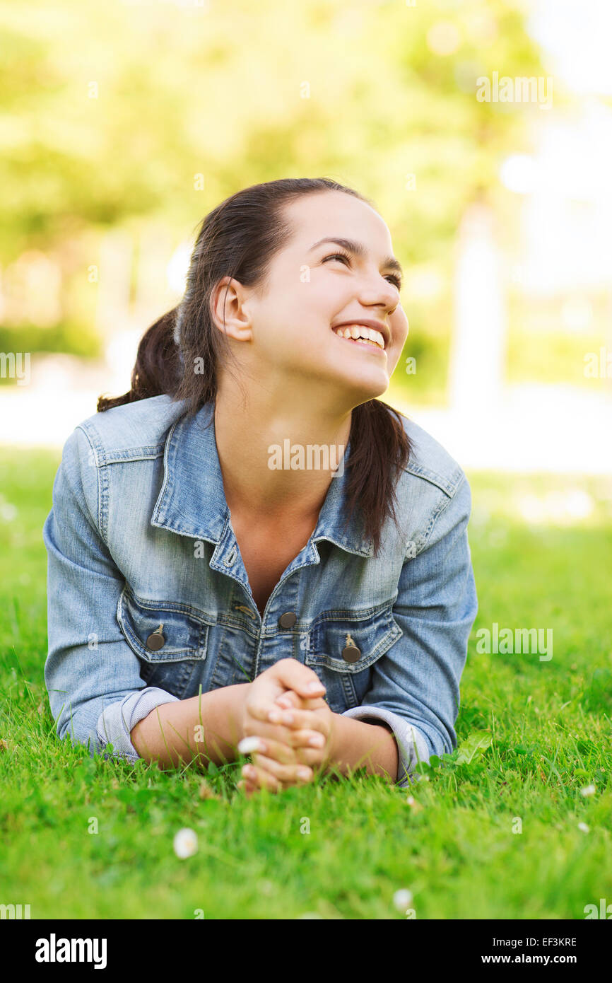 smiling young girl lying on grass Stock Photo - Alamy
