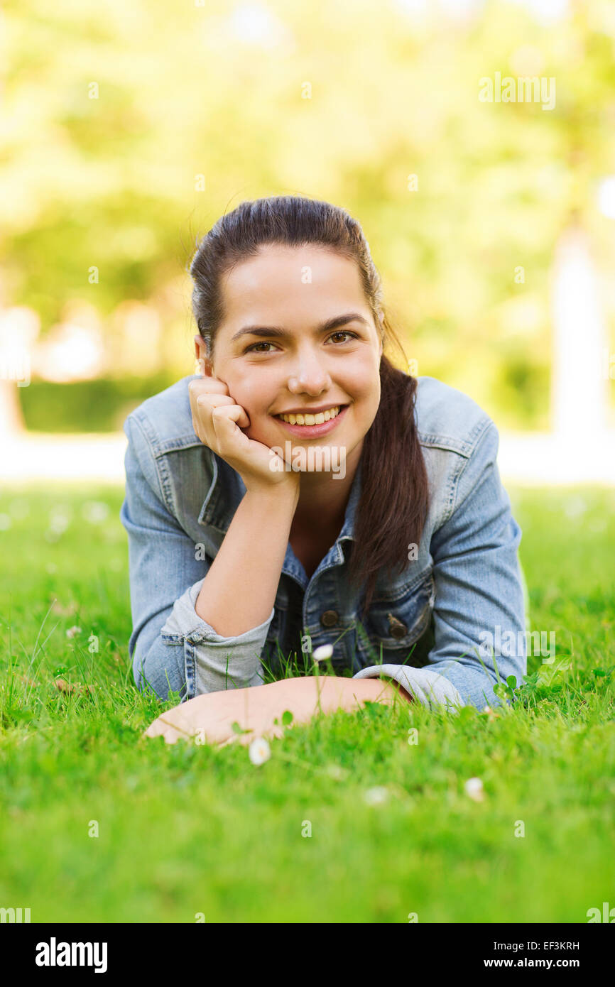 smiling young girl lying on grass Stock Photo - Alamy