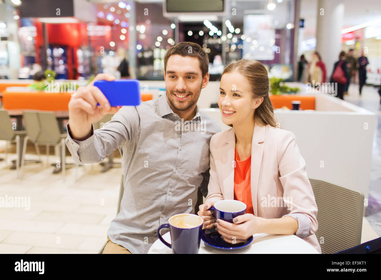 happy couple with smartphone taking selfie in mall Stock Photo - Alamy