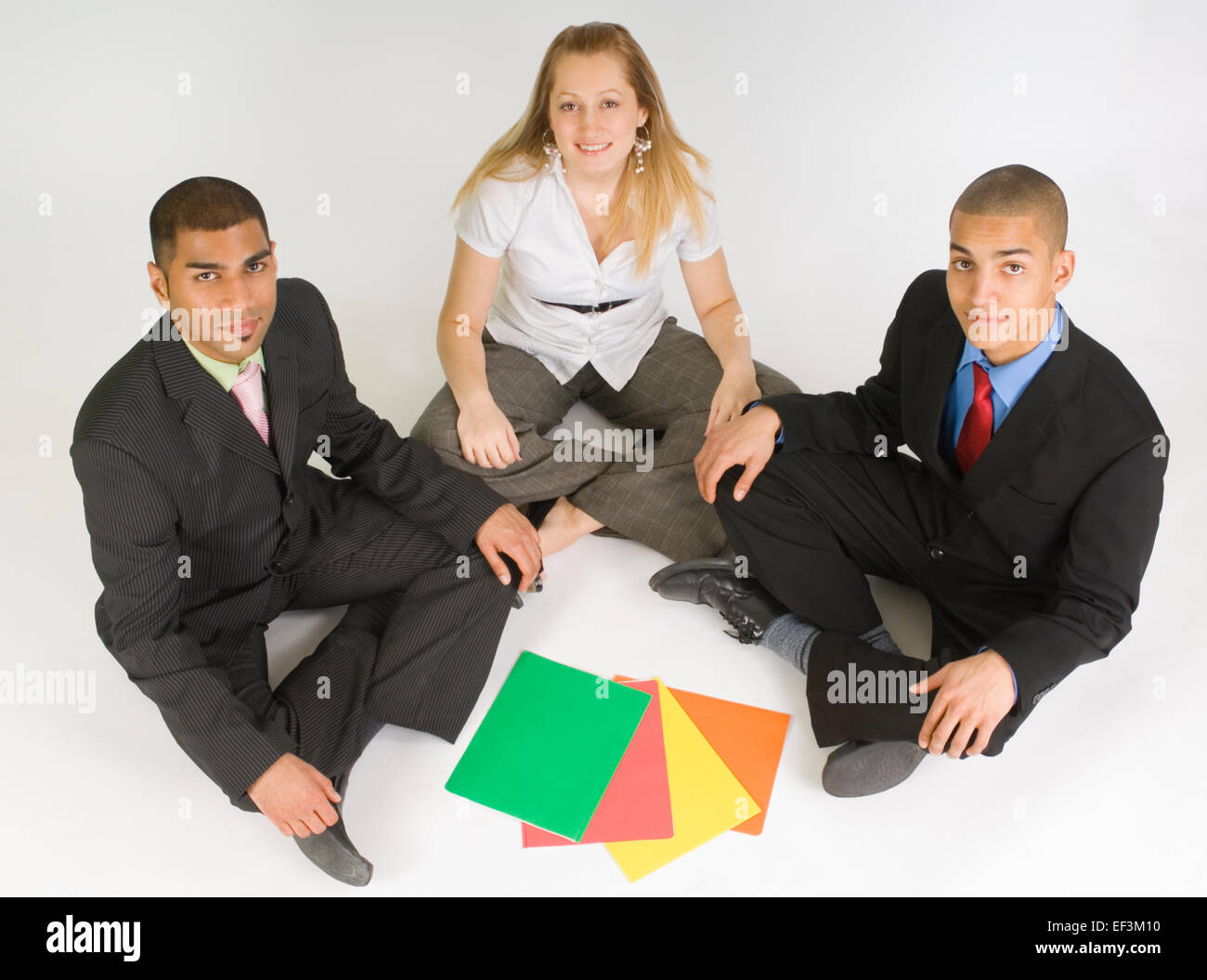 Business colleagues sitting cross legged on the floor Stock Photo