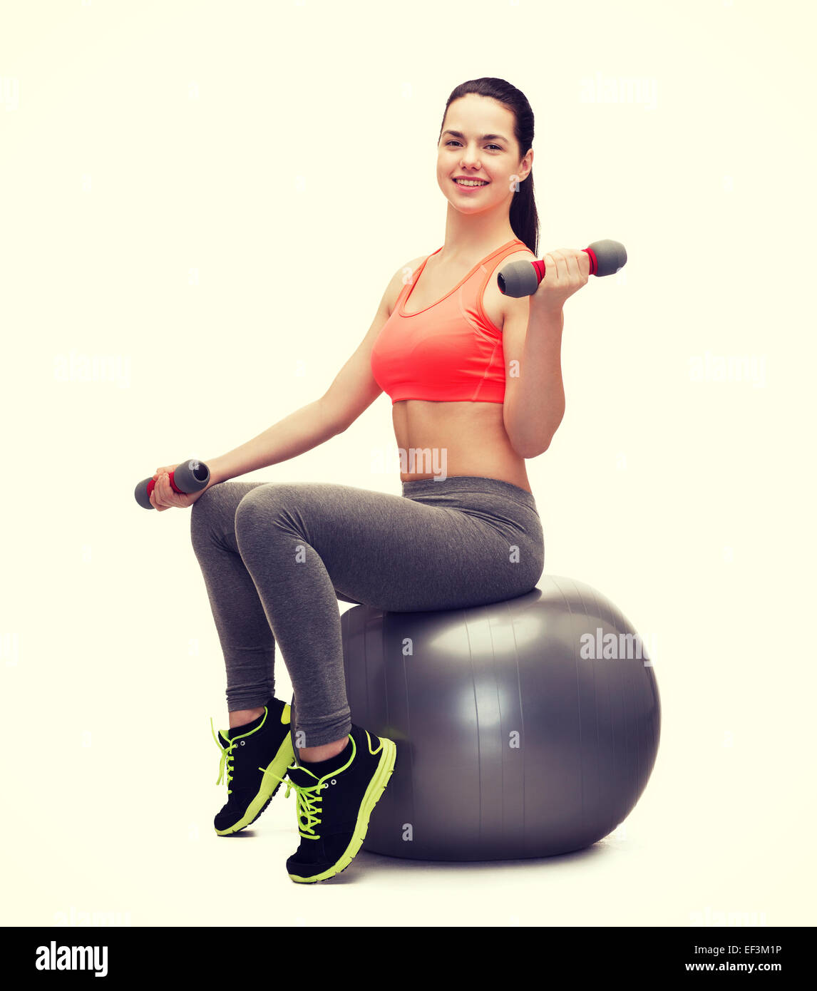 teenager with dumbbells sitting on fitness ball Stock Photo