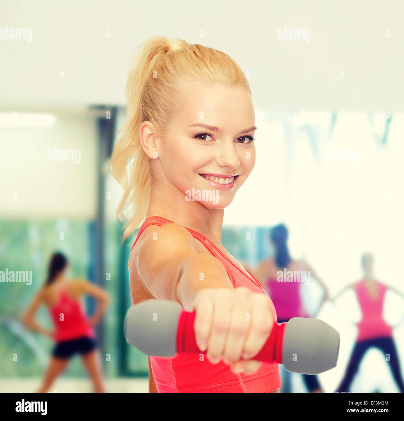 smiling beautiful sporty woman with dumbbell Stock Photo