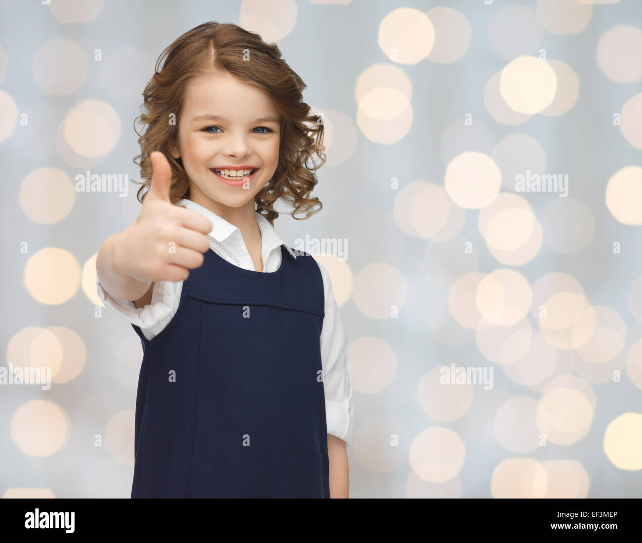 happy little school girl showing thumbs up Stock Photo - Alamy
