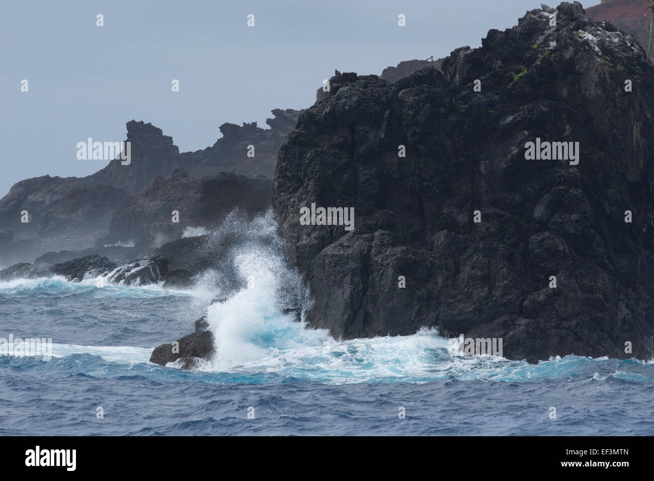 Pitcairn Islands, Pitcairn Island. Coastal view of the rugged volcanic shore of Pitcairn. Rough seas. Stock Photo