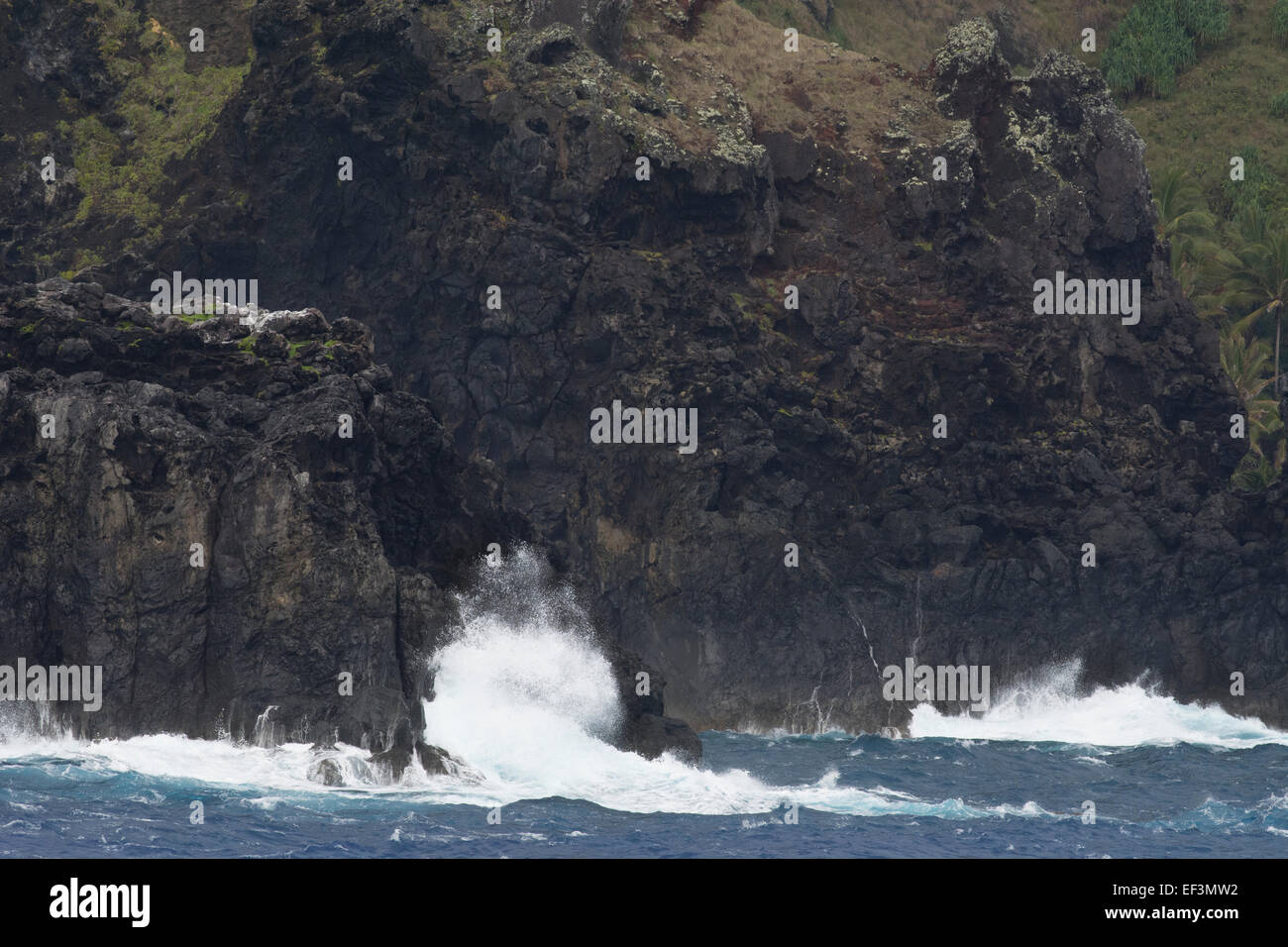 Pitcairn Islands, Pitcairn Island. Coastal view of the rugged volcanic shore of Pitcairn. Rough seas. Stock Photo