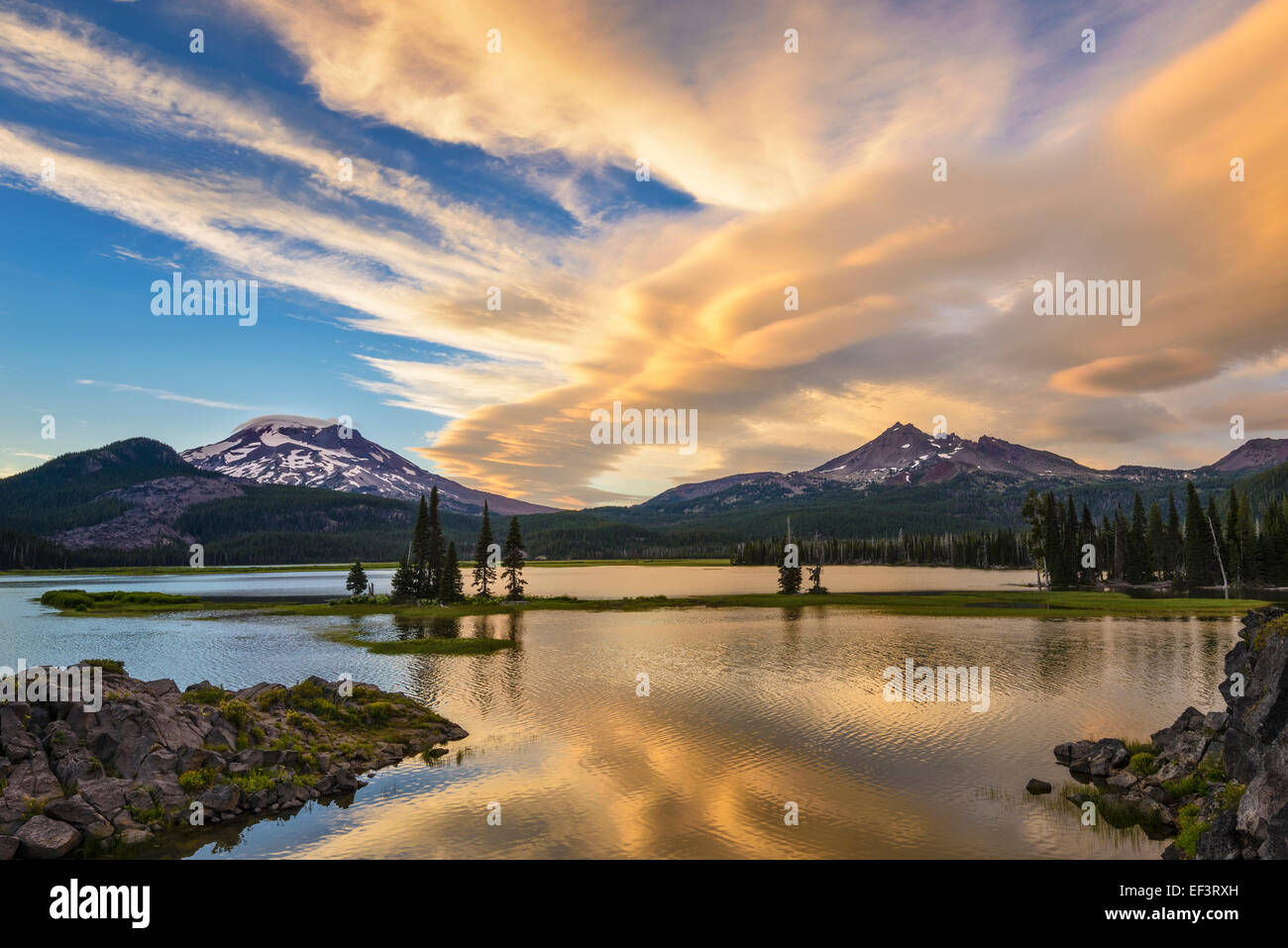 Sunset clouds over Broken Top and South Sister from Ray Atkeson Memorial viewpoint at Sparks Lake; Cascade Mountains, Oregon. Stock Photo