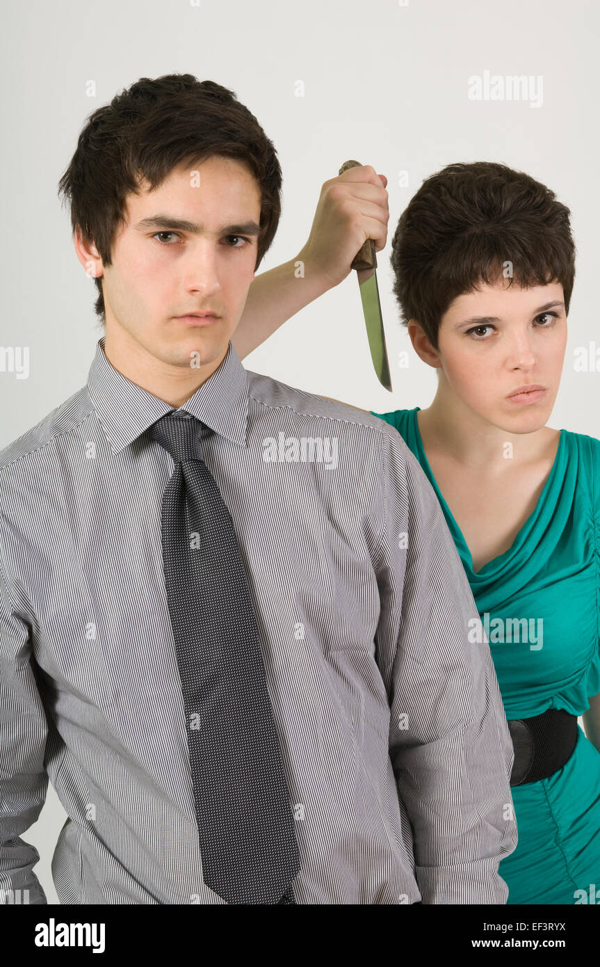 Woman holding a knife behind a man Stock Photo Alamy