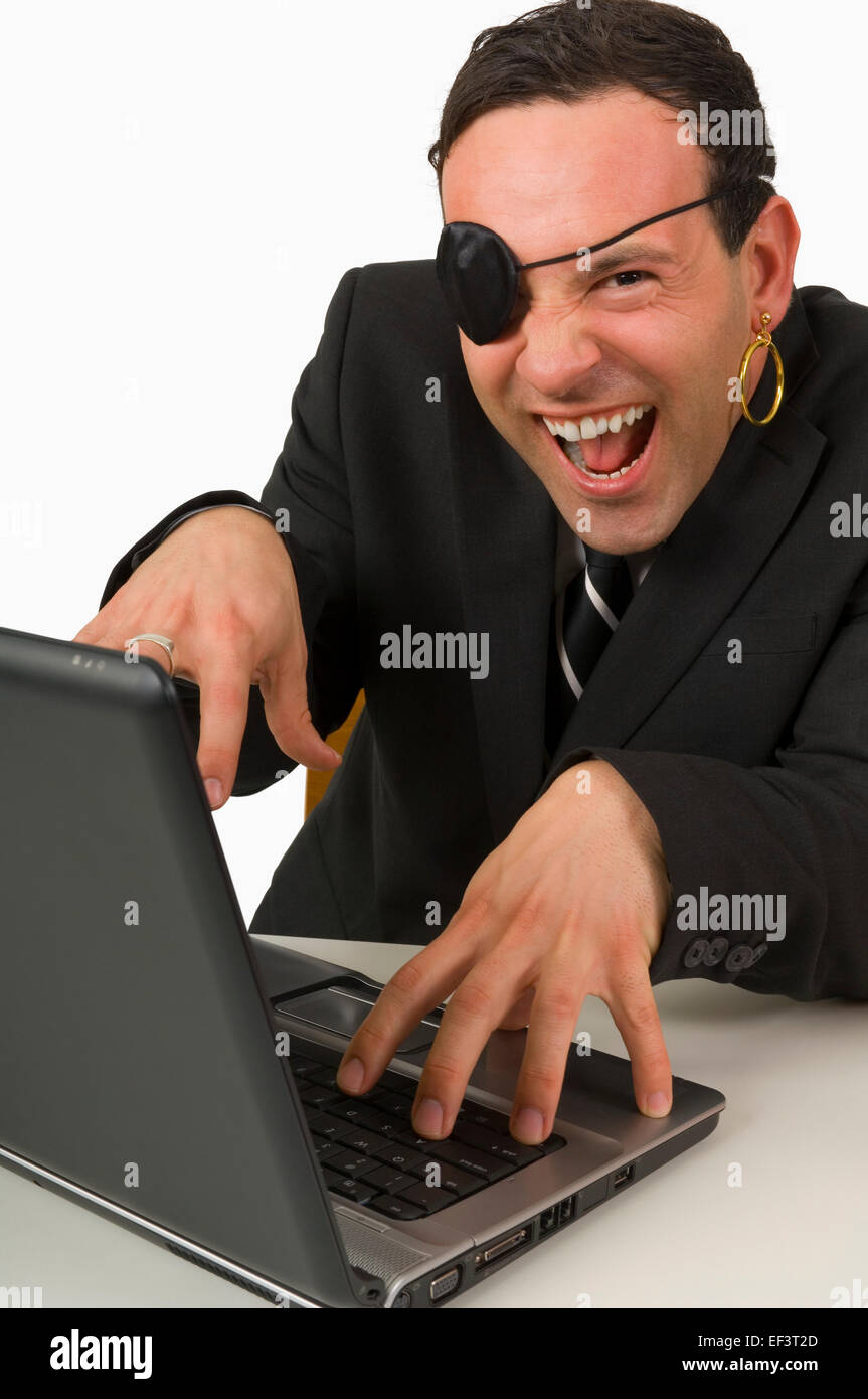 Man wearing eye patch typing on laptop Stock Photo
