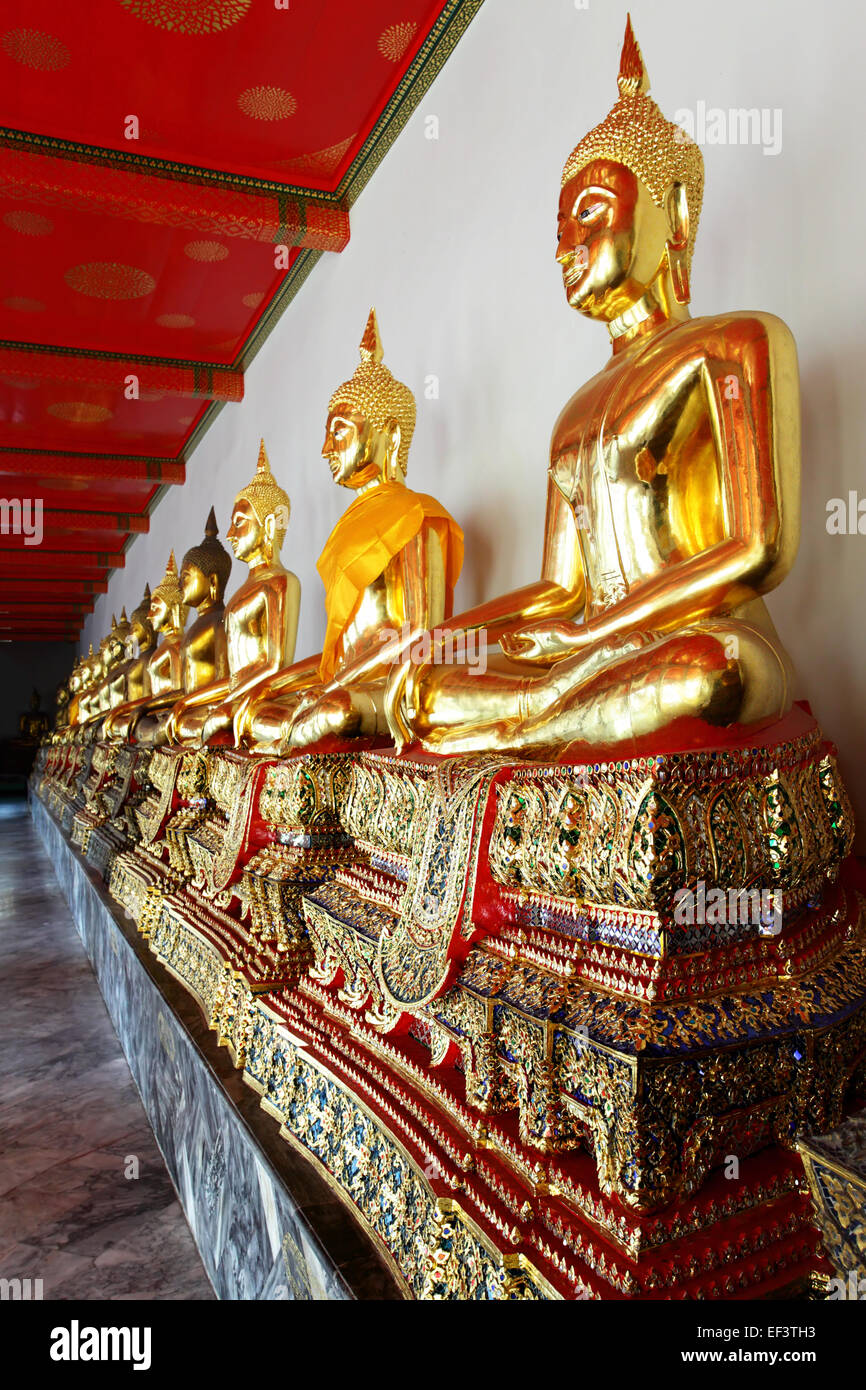 Gold statues of the Buddha abreast at Wat Pho, Bangkok, Thailand Stock Photo
