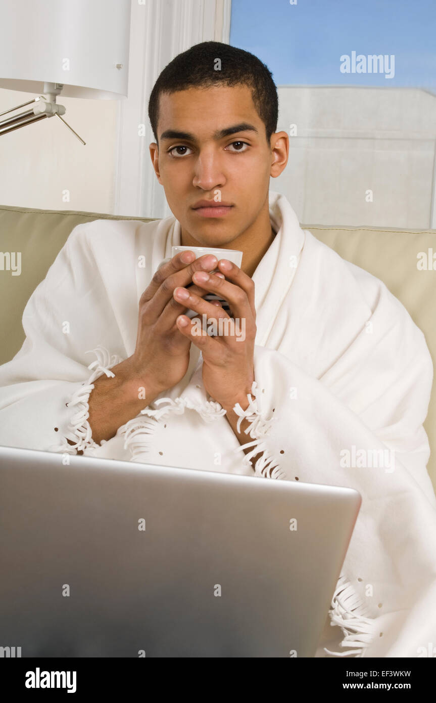 Man with a cold working on laptop Stock Photo