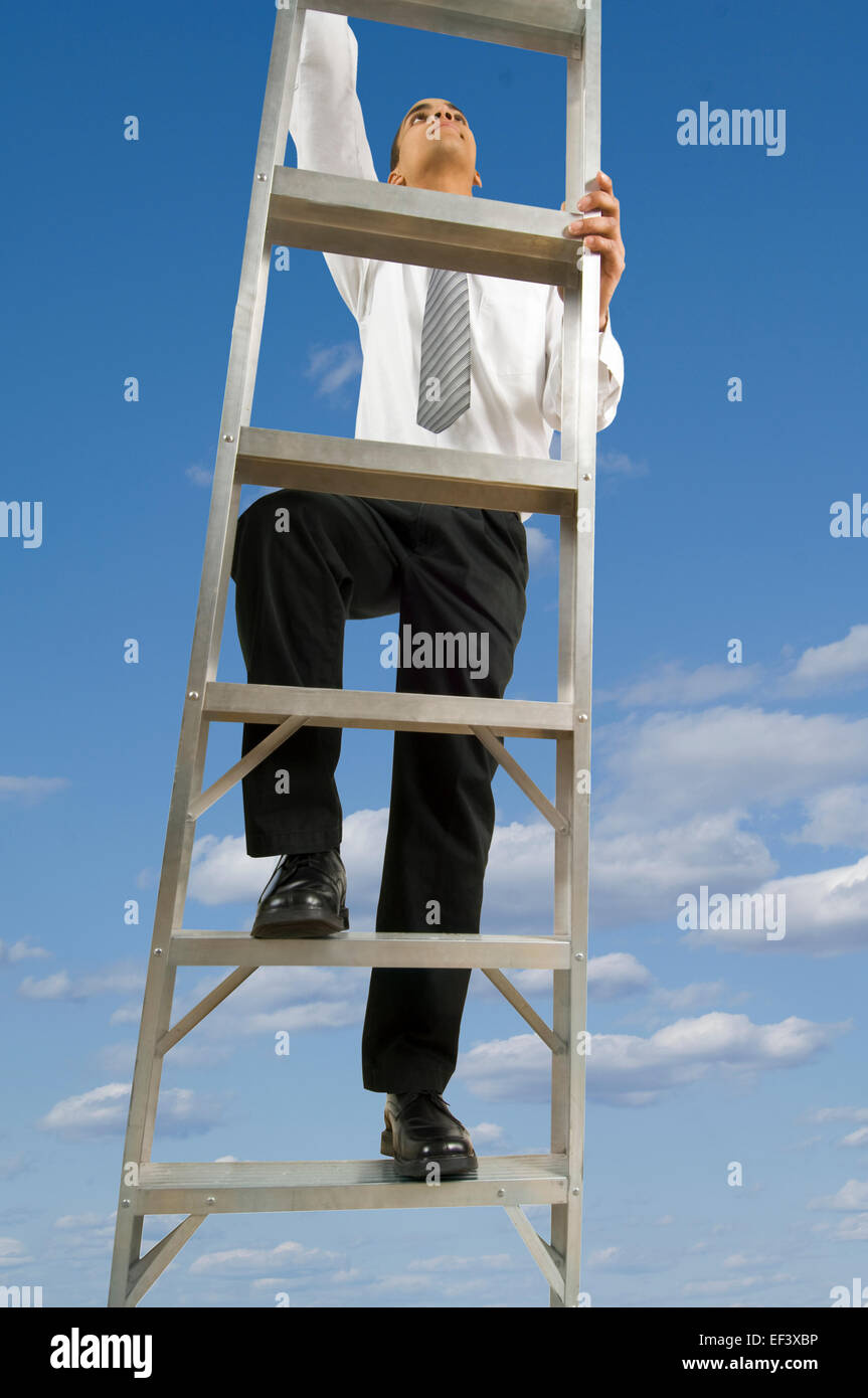 Businessman climbing ladder in the sky Stock Photo Alamy