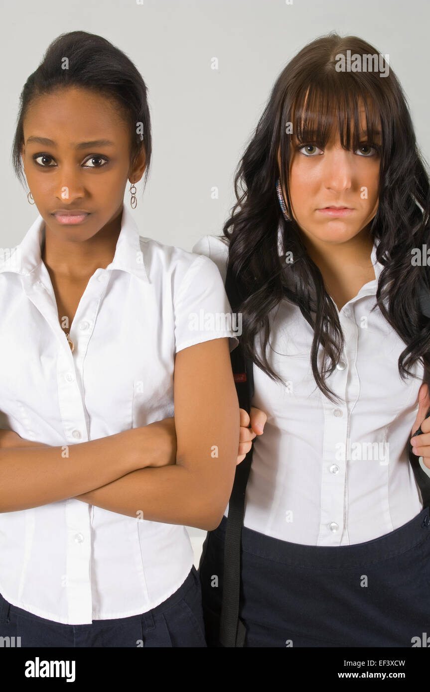Two unhappy young women standing side by side Stock Photo - Alamy