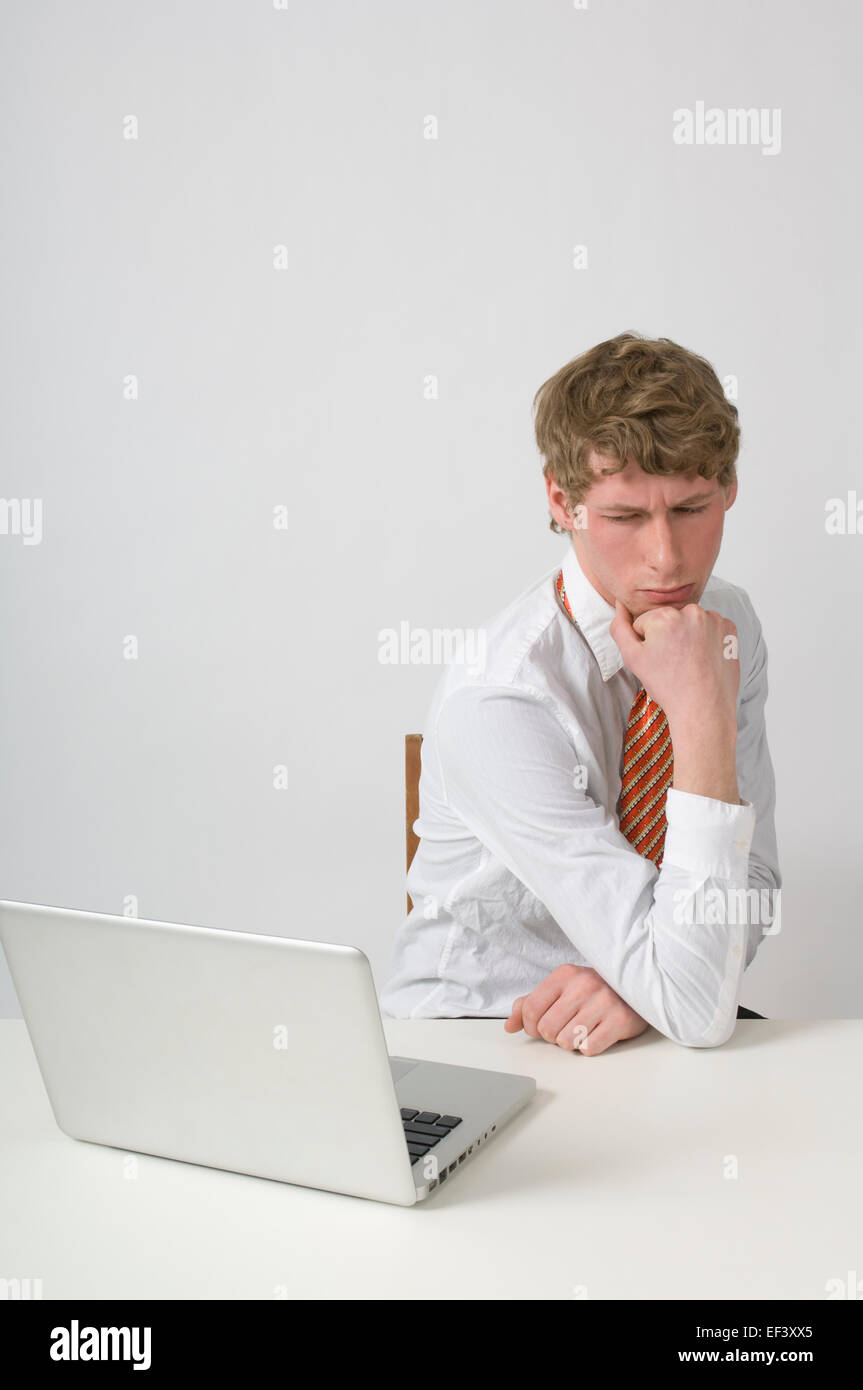 Man deep in thought at his desk Stock Photo