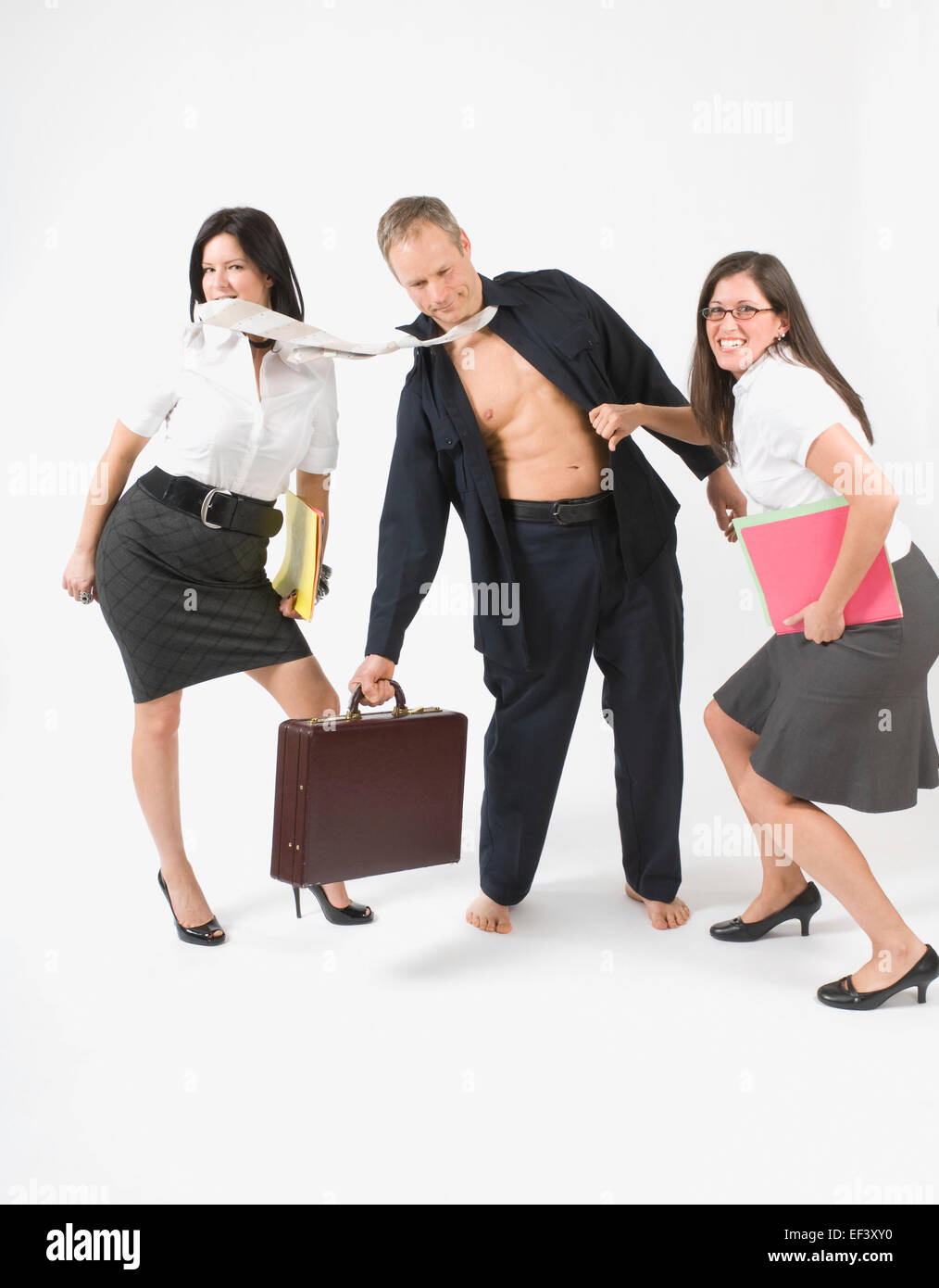 Women ripping the clothing off a man Stock Photo