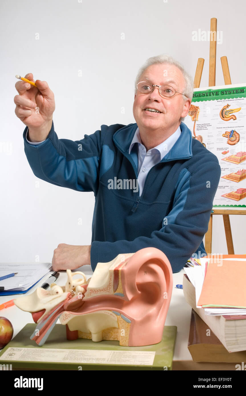 Teacher sitting at his desk Stock Photo