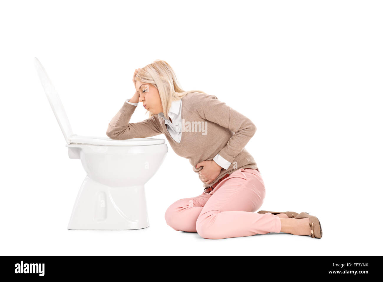 Woman throwing up in the toilet isolated on white background Stock Photo