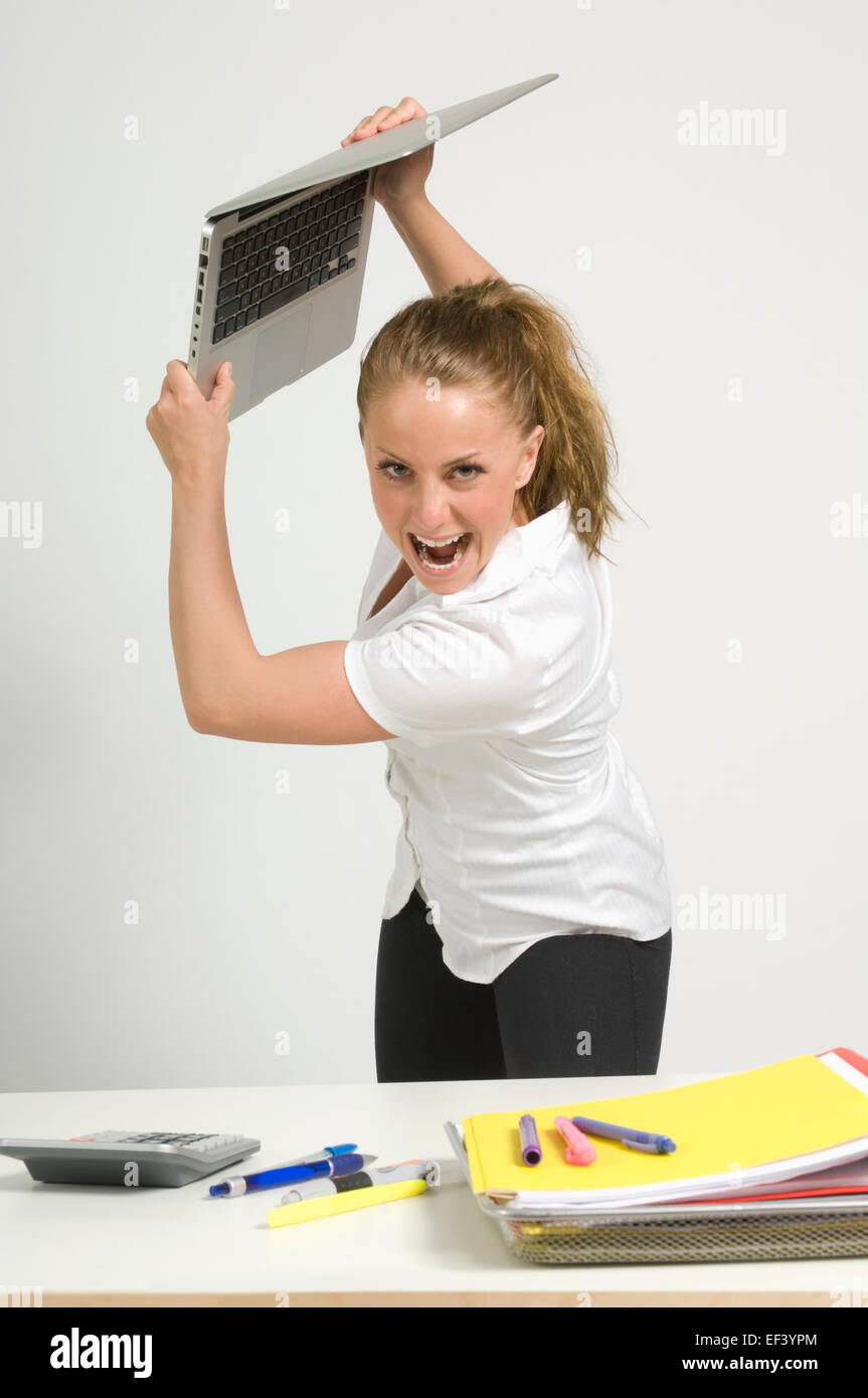 Angry woman about to throw a laptop Stock Photo