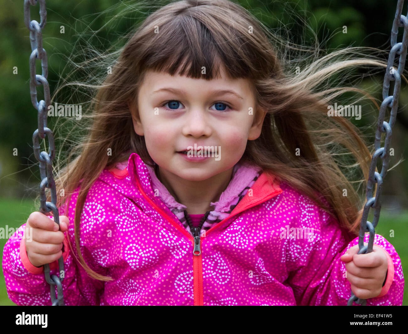 Young girl on a swing with hair blowing in the breeze Stock Photo - Alamy