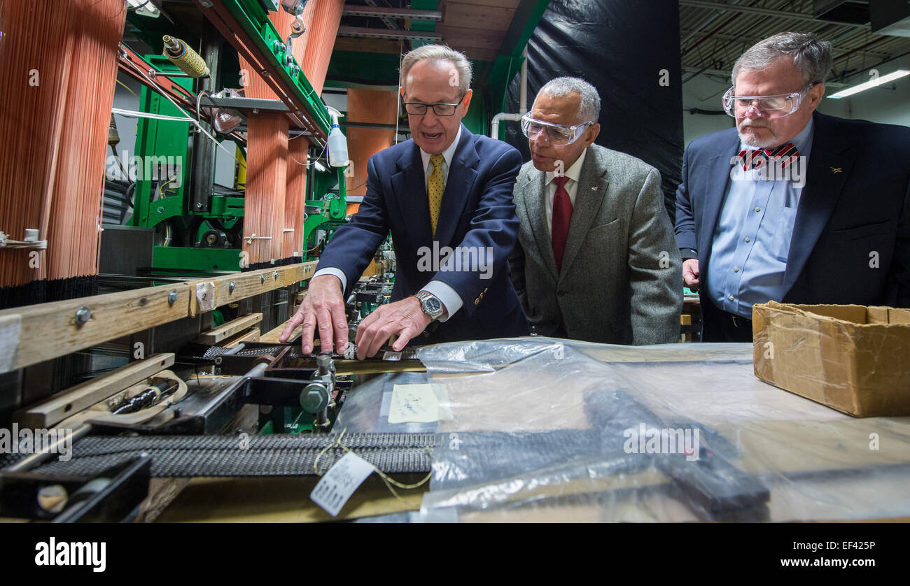 Bally Ribbon Mills (BRM) President Ray Harries, left, shows a carbon fiber weaving loom to NASA Administrator Charles Bolden, center, and, Vice President and Orion program manager for Lockheed Martin space systems company Mike Hawes during a tour of the BRM manufacturing facility on Friday, Jan. 9, 2015 in Bally, PA. BRM is weaving the multifunctional 3D thermal protection system padding used to insulate and protect NASA's Orion spacecraft. NASA's recently-tested Orion spacecraft will carry astronauts to Mars and return them safely back to Earth with the help of BRM technology. New woven compo Stock Photo