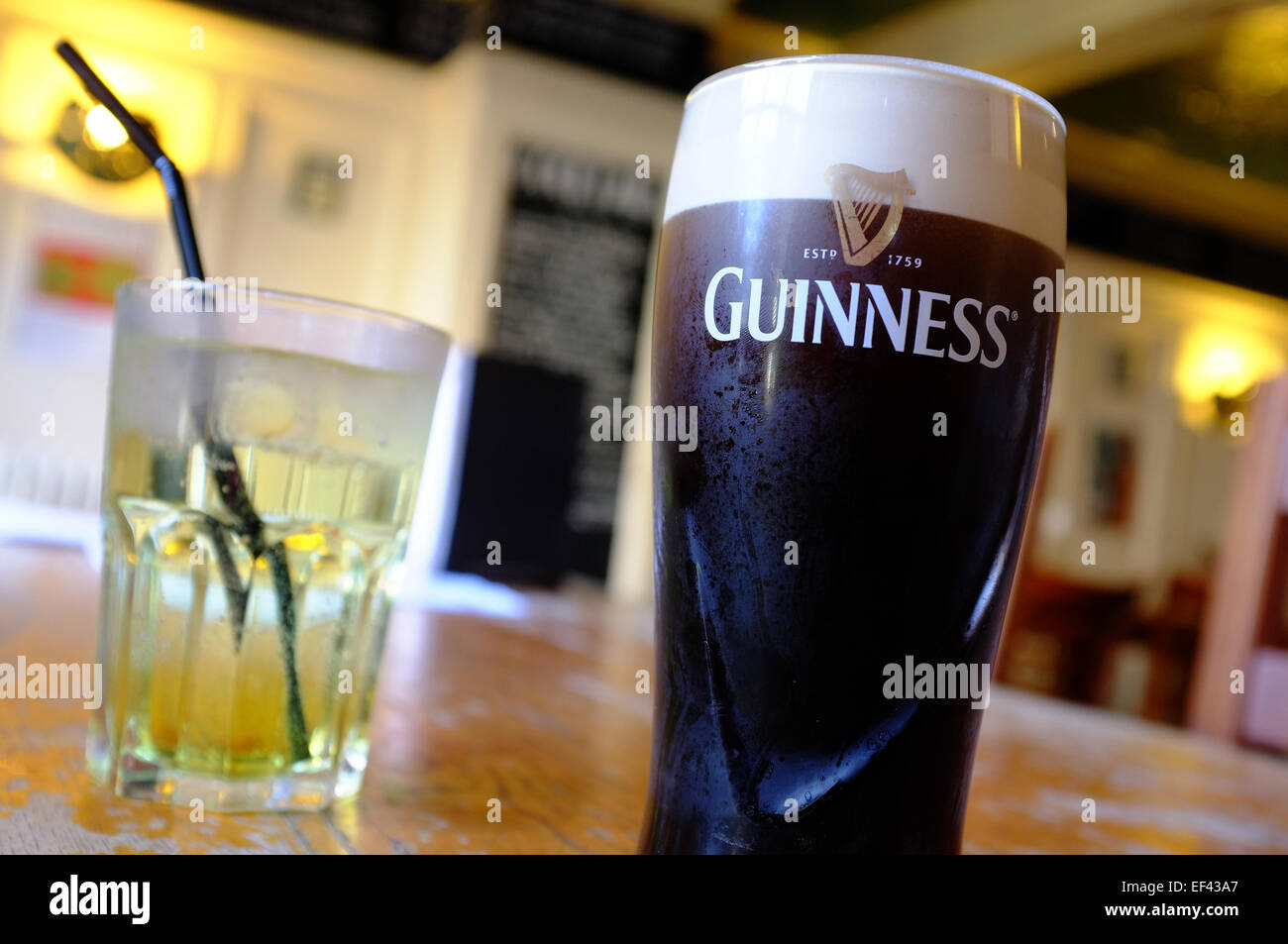 A pint of Guinness and a vodka, lime and lemonade on a bar table in Brighton. Stock Photo