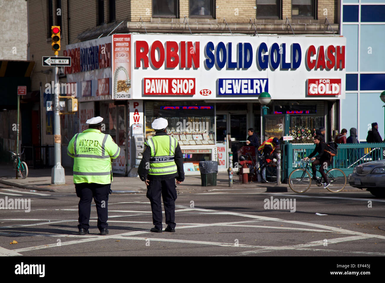 Two NYPD officers stand on a street in New York, NY and look at a pawn shop. Stock Photo