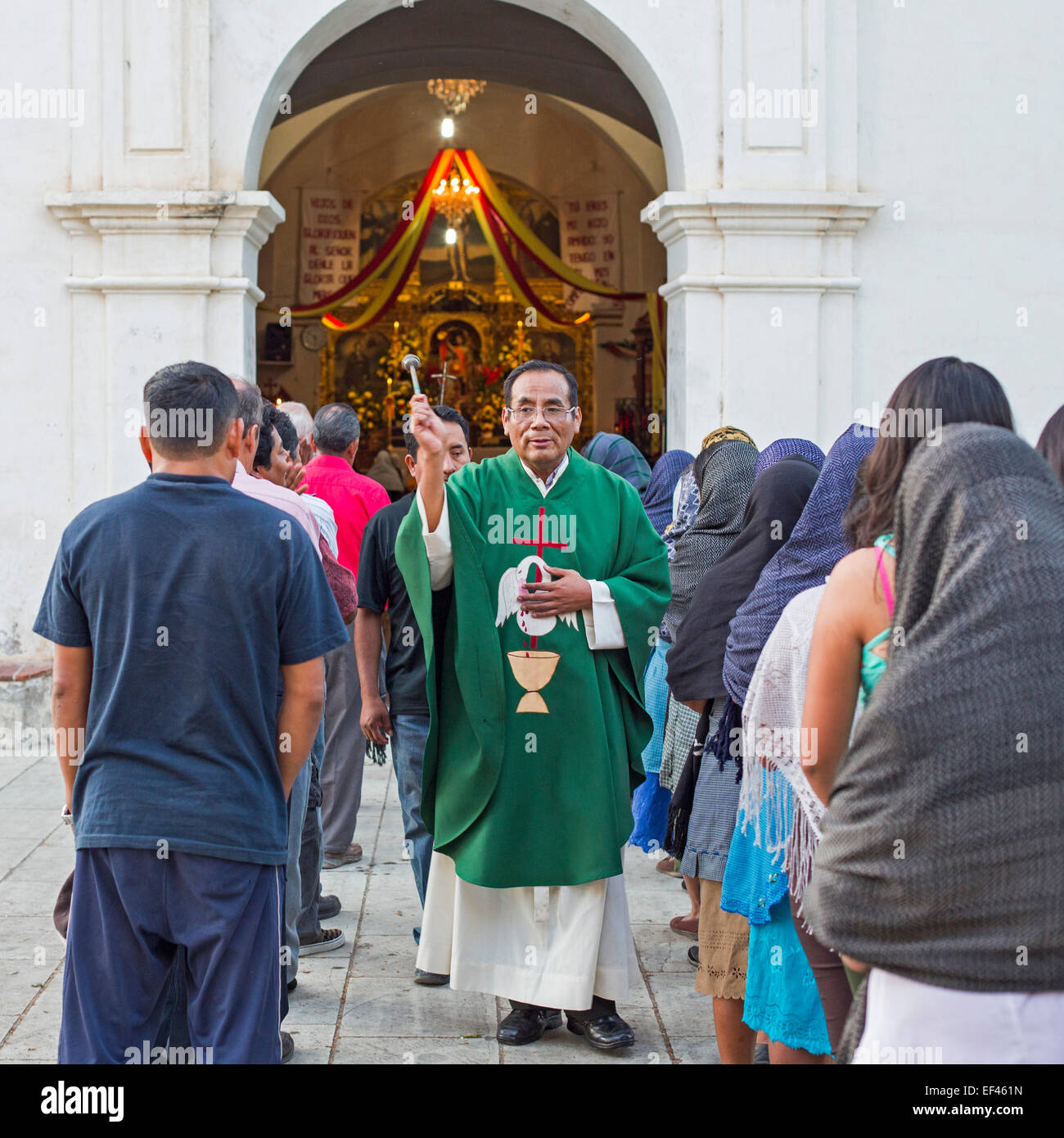 San Sebastian Abasolo, Oaxaca, Mexico - Fr. Victorio Nickolas Velasco sprinkles holy water before mass. Stock Photo