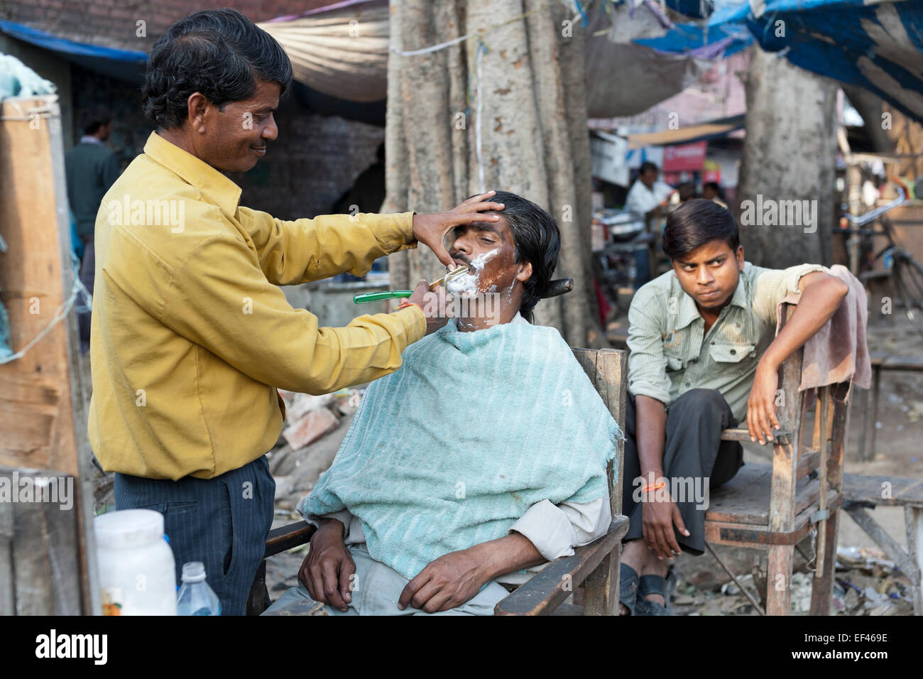 Agra, India, South Asia. Roadside barber at Kinari Bazaar, in the heart of the old town Stock Photo