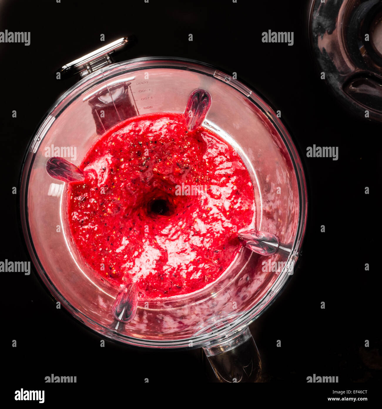Mixed berries in a blender viewed from the top as they are being liquidized. Stock Photo