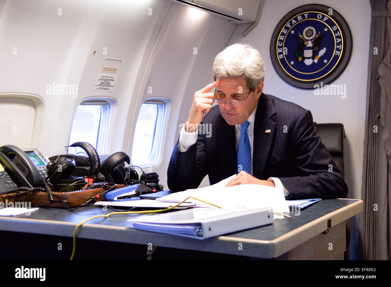 U.S. Secretary of State John Kerry sits in the cabin of his Air Force jet, working on the speech he was to deliver at the World Economic Forum in Davos, Switzerland, after arriving in Zurich, Switzerland, on January 23, 2015. Stock Photo