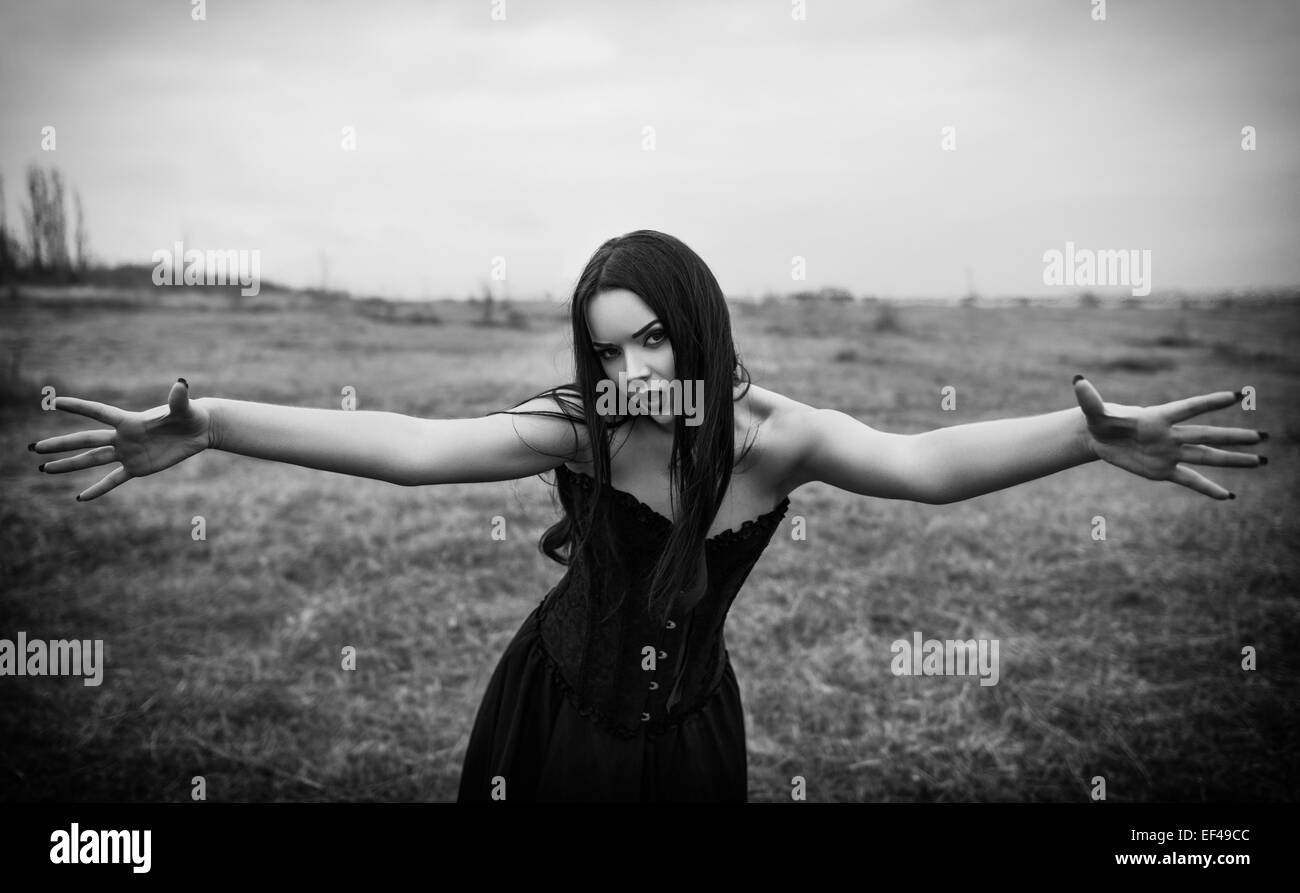 Wicked dangerous goth girl in the autumnal field. Black and white Stock Photo