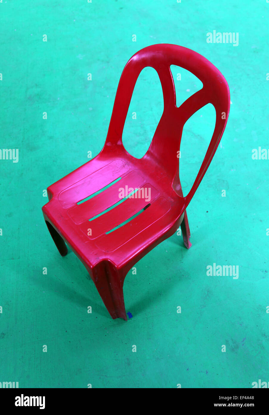 Red plastic chair on a green background top view. there is nobody on it