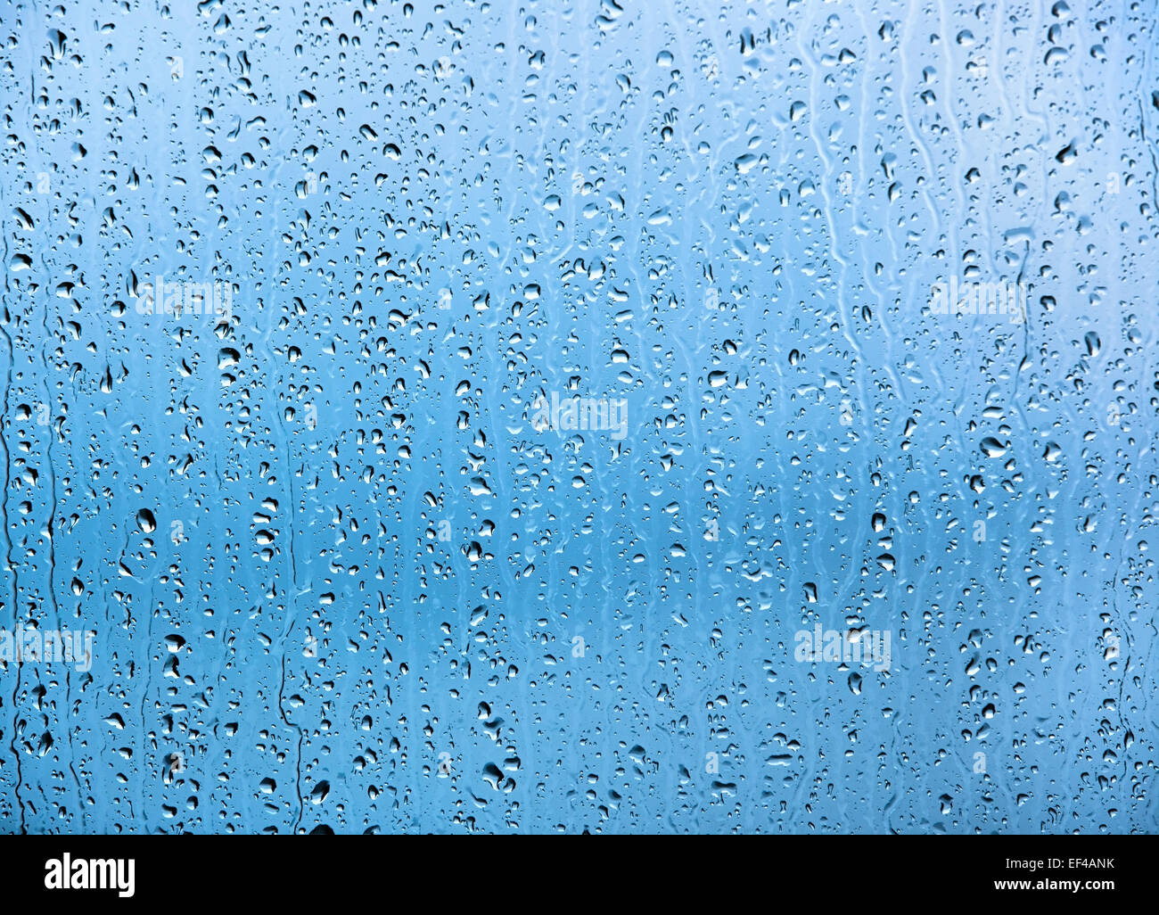 Water drops on glass texture or background. Blue tint. Stock Photo