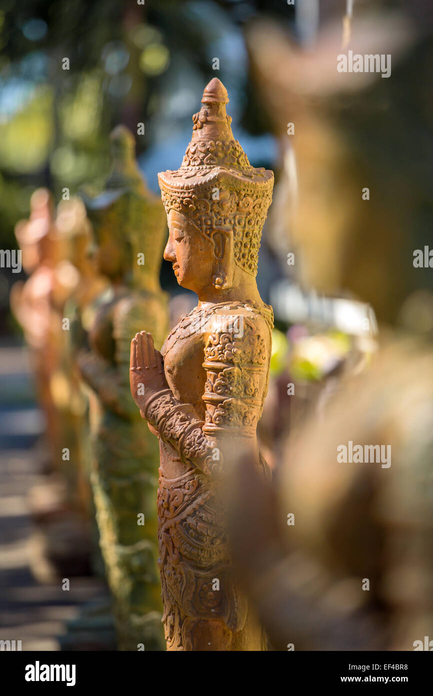 Clay praying women statue in the buddhist temple in Thailand Stock Photo