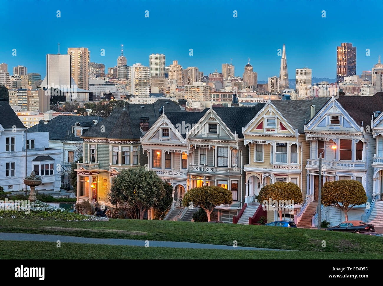 The iconic 'Painted Ladies' with Downtown San Francisco Skyline behind photographed after sunset from Alamo Square in San Francisco, California. Stock Photo