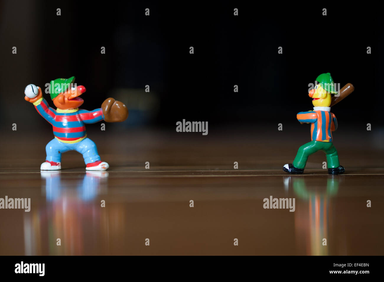 Figurines of Bert and Ernie (Muppets from the children's TV show, Sesame Street) playing baseball. Stock Photo