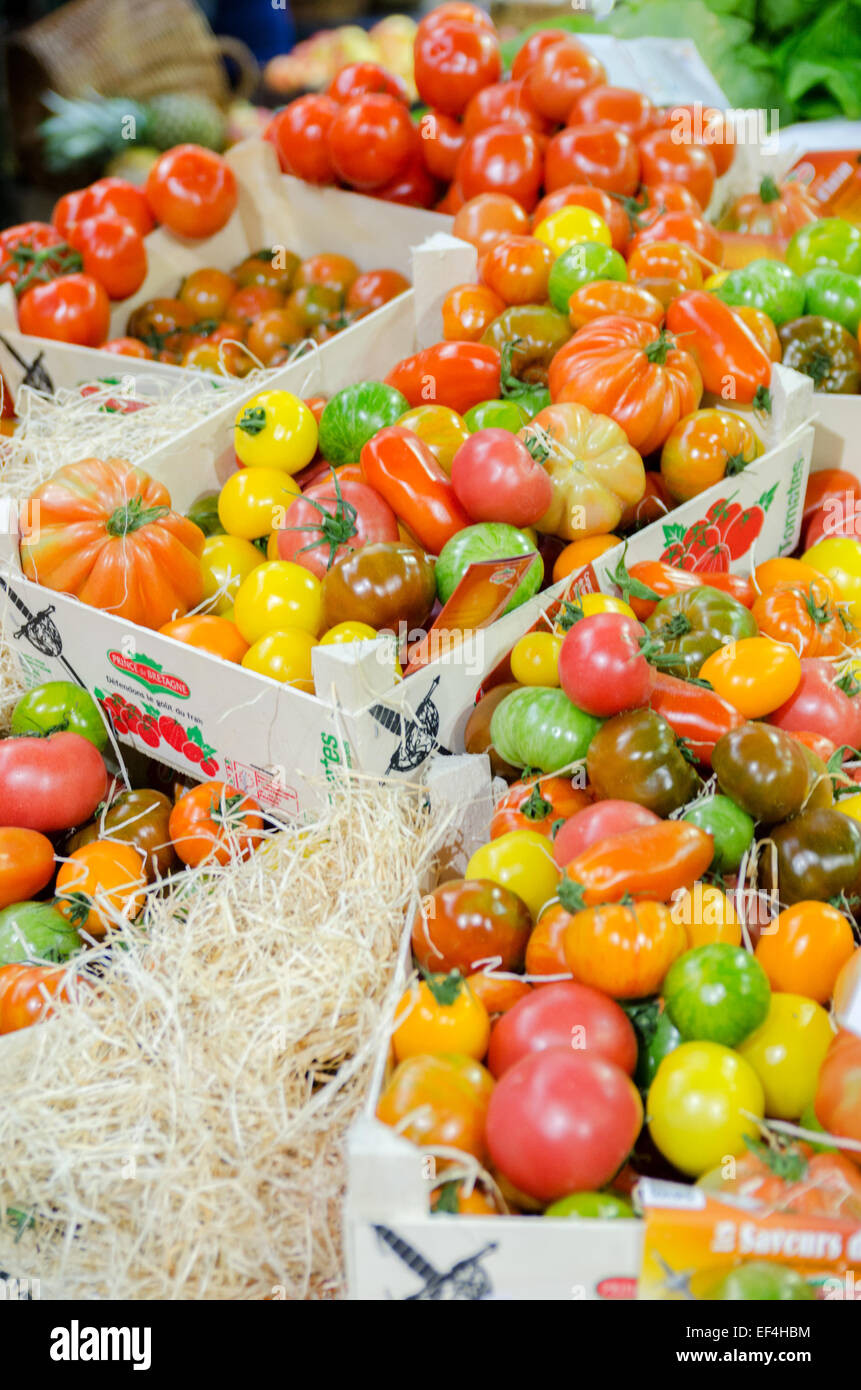 Fresh Heritage tomatoes in rustic crates on a market stall at London's Borough Market Stock Photo