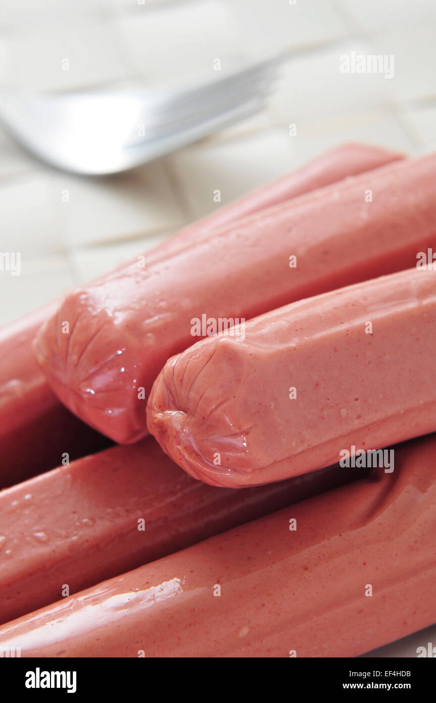 closeup of some raw hot dogs ready to be grilled on a table Stock Photo