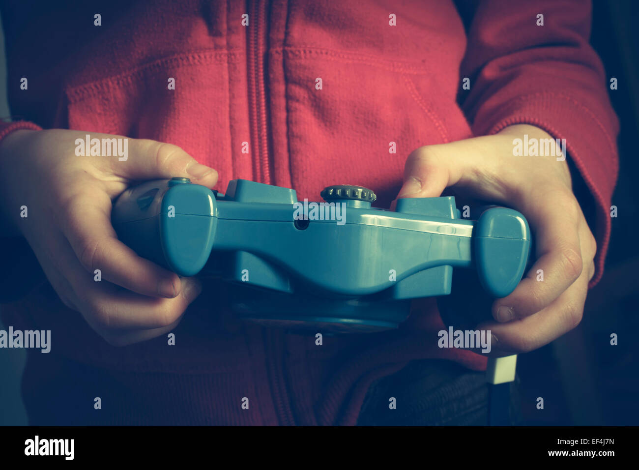 Young boy indoors playing a video game. Stock Photo