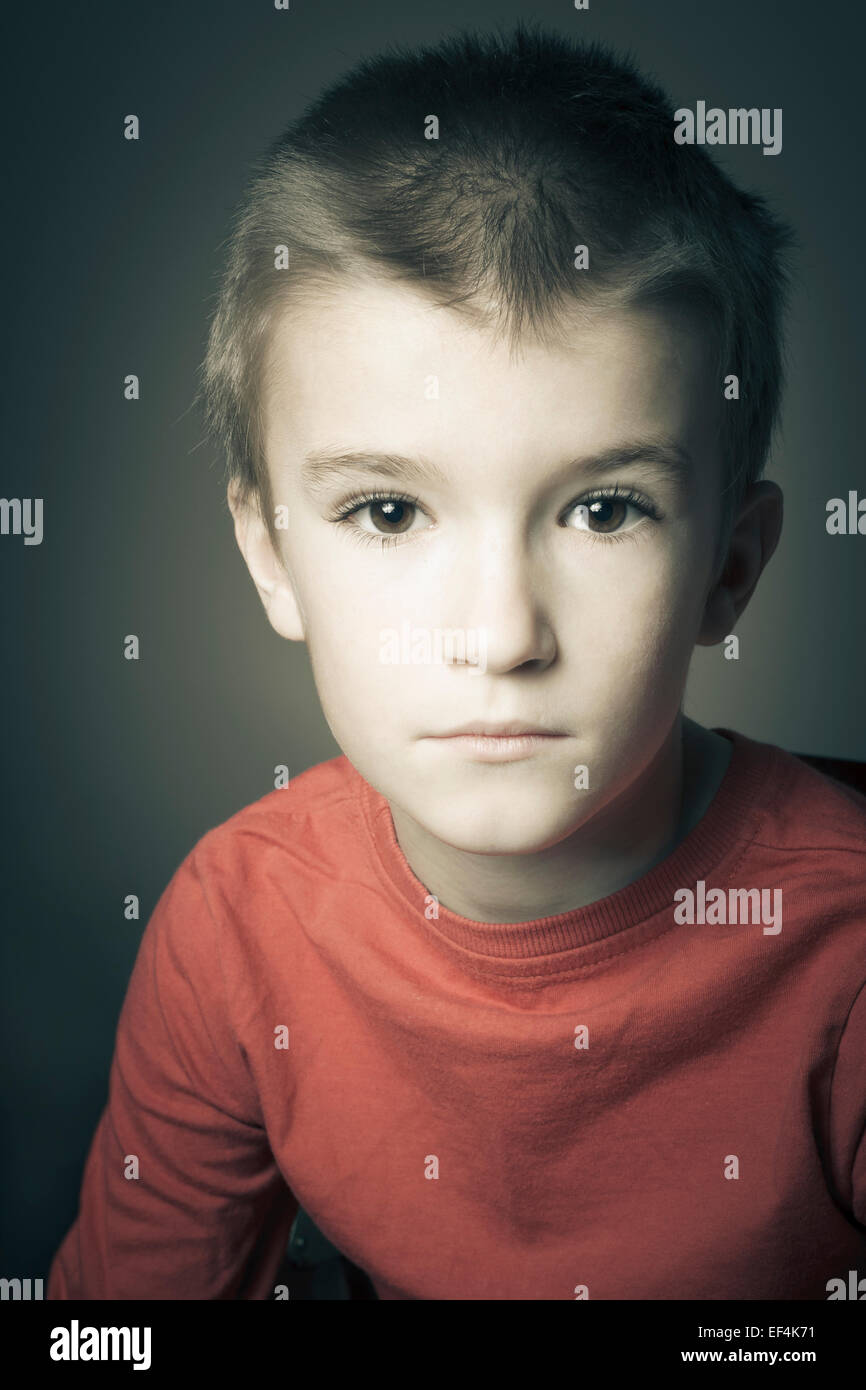 Young boy indoors looking at camera Stock Photo - Alamy
