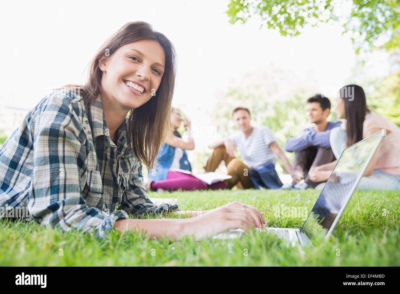 Happy student using her laptop outside Stock Photo - Alamy