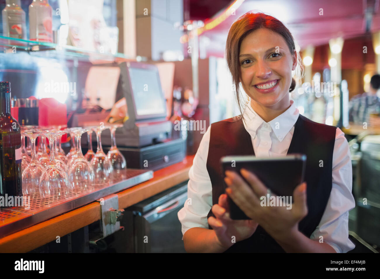 Focused barmaid using touchscreen till Stock Photo