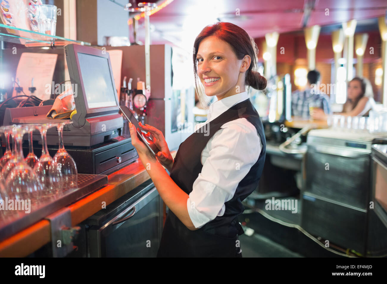 Pretty barmaid using touchscreen till Stock Photo