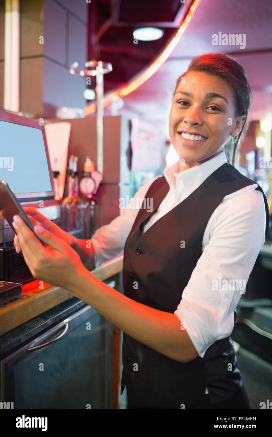 Pretty barmaid using touchscreen till Stock Photo
