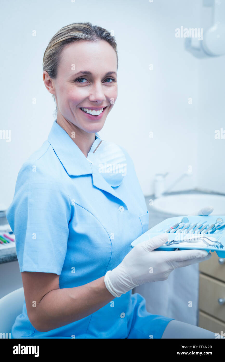 Female dentist in blue scrubs holding tray of tools Stock Photo Alamy