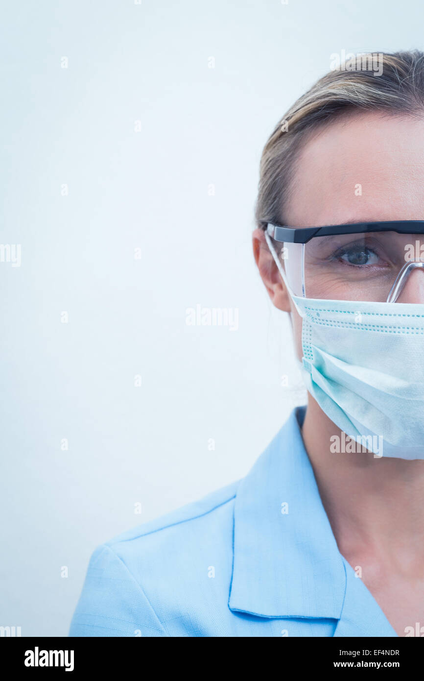 Female dentist wearing surgical mask and safety glasses Stock Photo