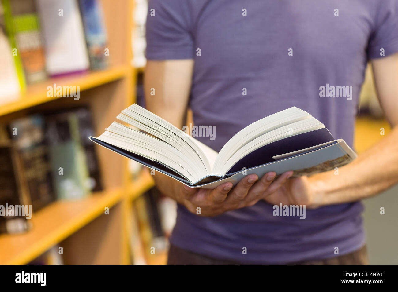 University student standing holding textbook Stock Photo