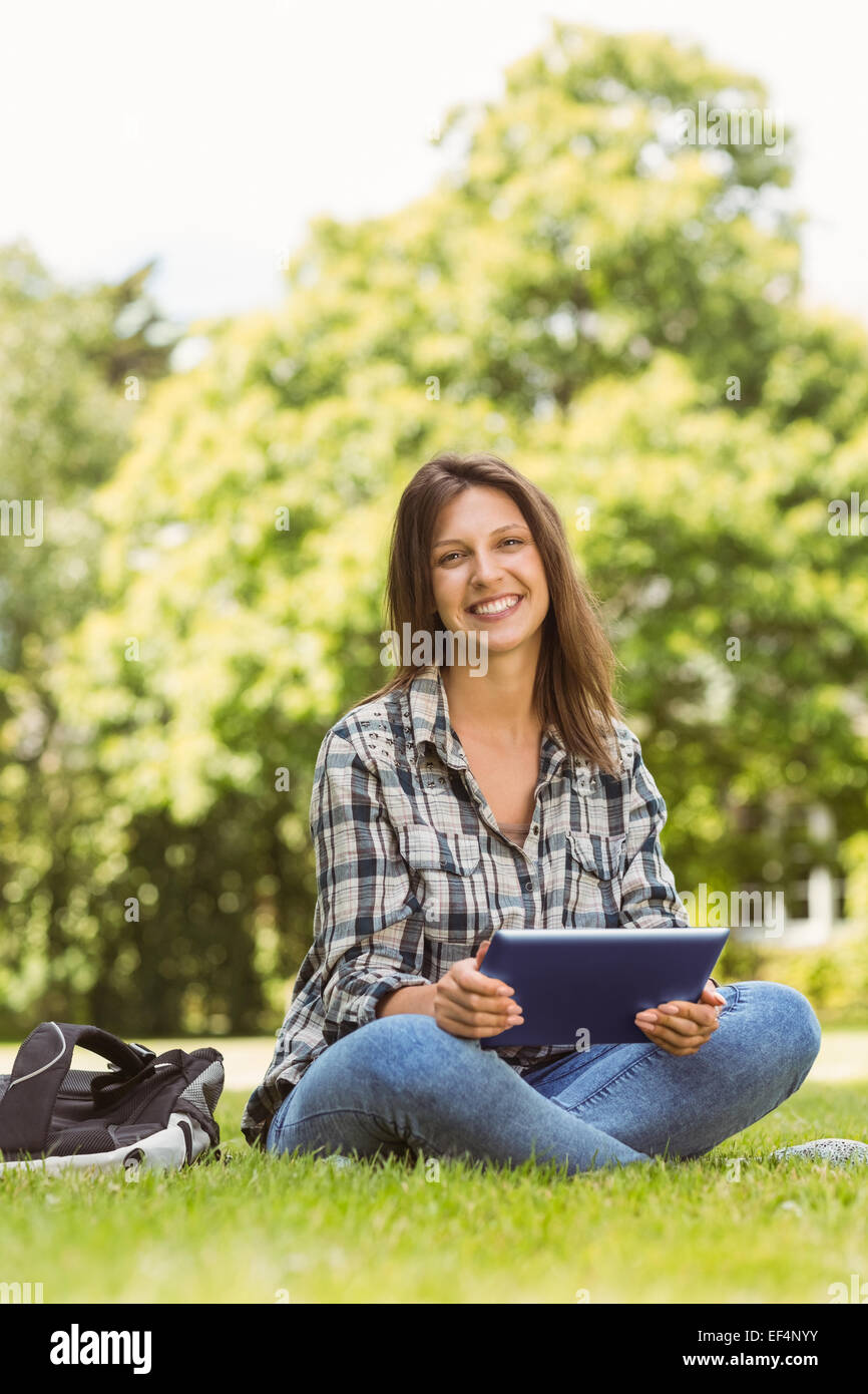 Smiling student sitting and using tablet pc Stock Photo - Alamy