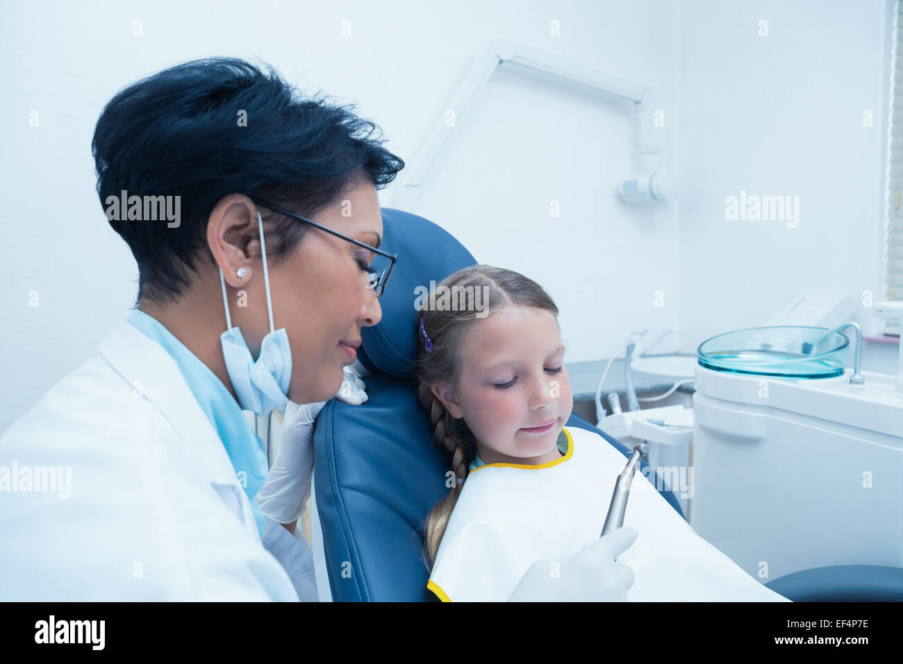 Female dentist examining girls teeth Stock Photo