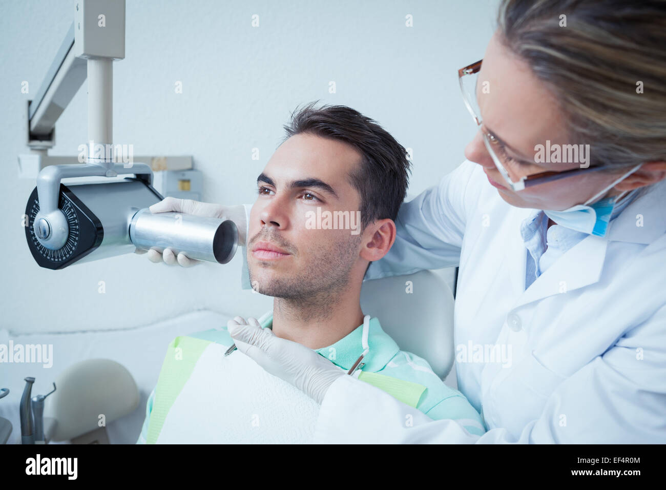 Serious young man undergoing dental checkup Stock Photo